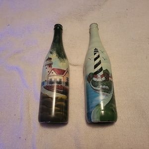 Two hand-painted lighthouse distressed wine bottles.